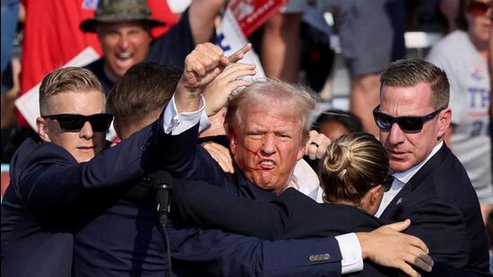 Former US President Donald Trump being assisted by the Secret Service after he was shot at a campaign rally in Pennsylvania on Saturday evening.